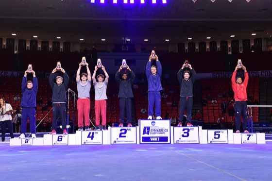 Gymnasts raising their arms on the awards podium
